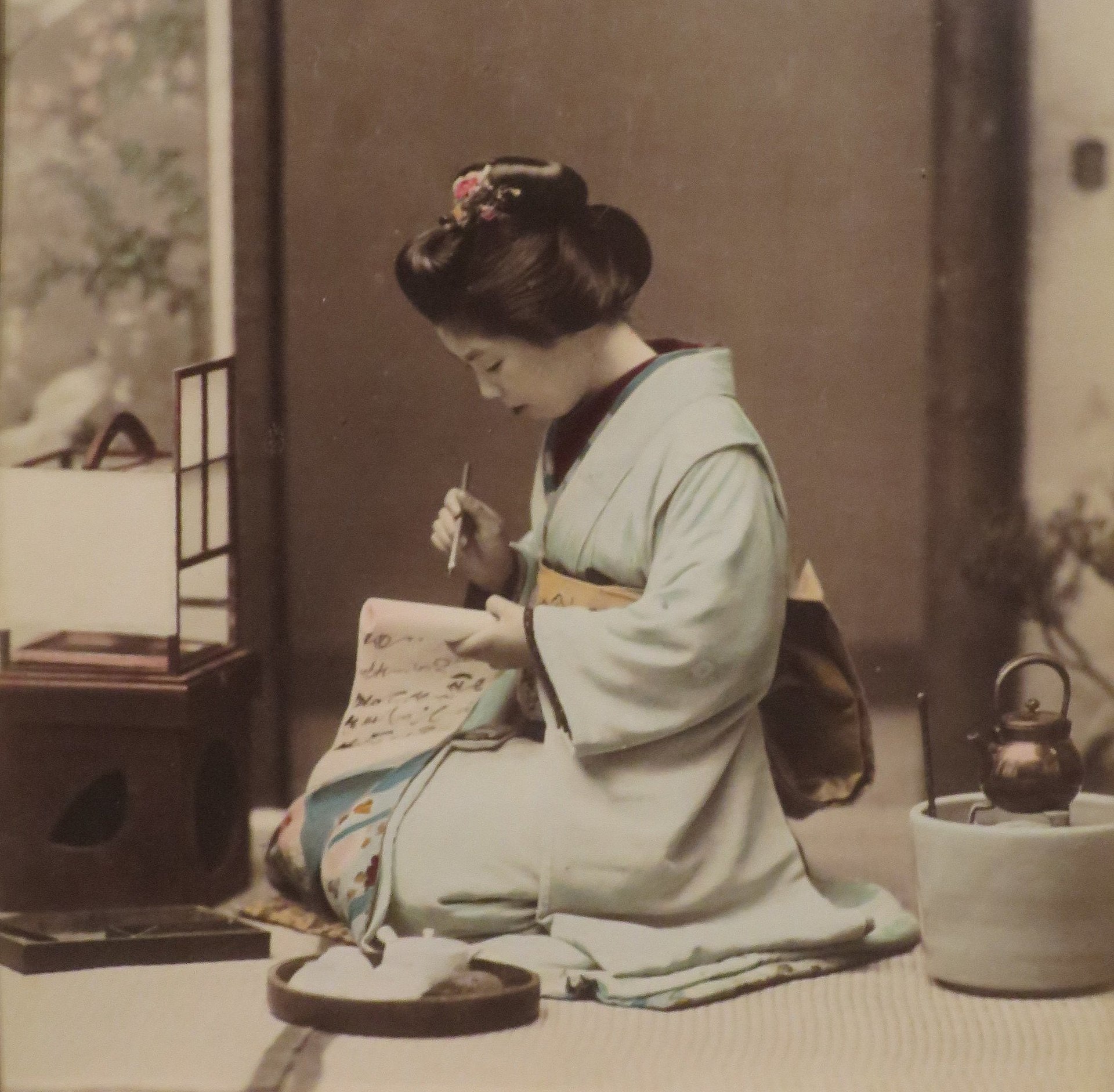 A hand drafting a letter on paper