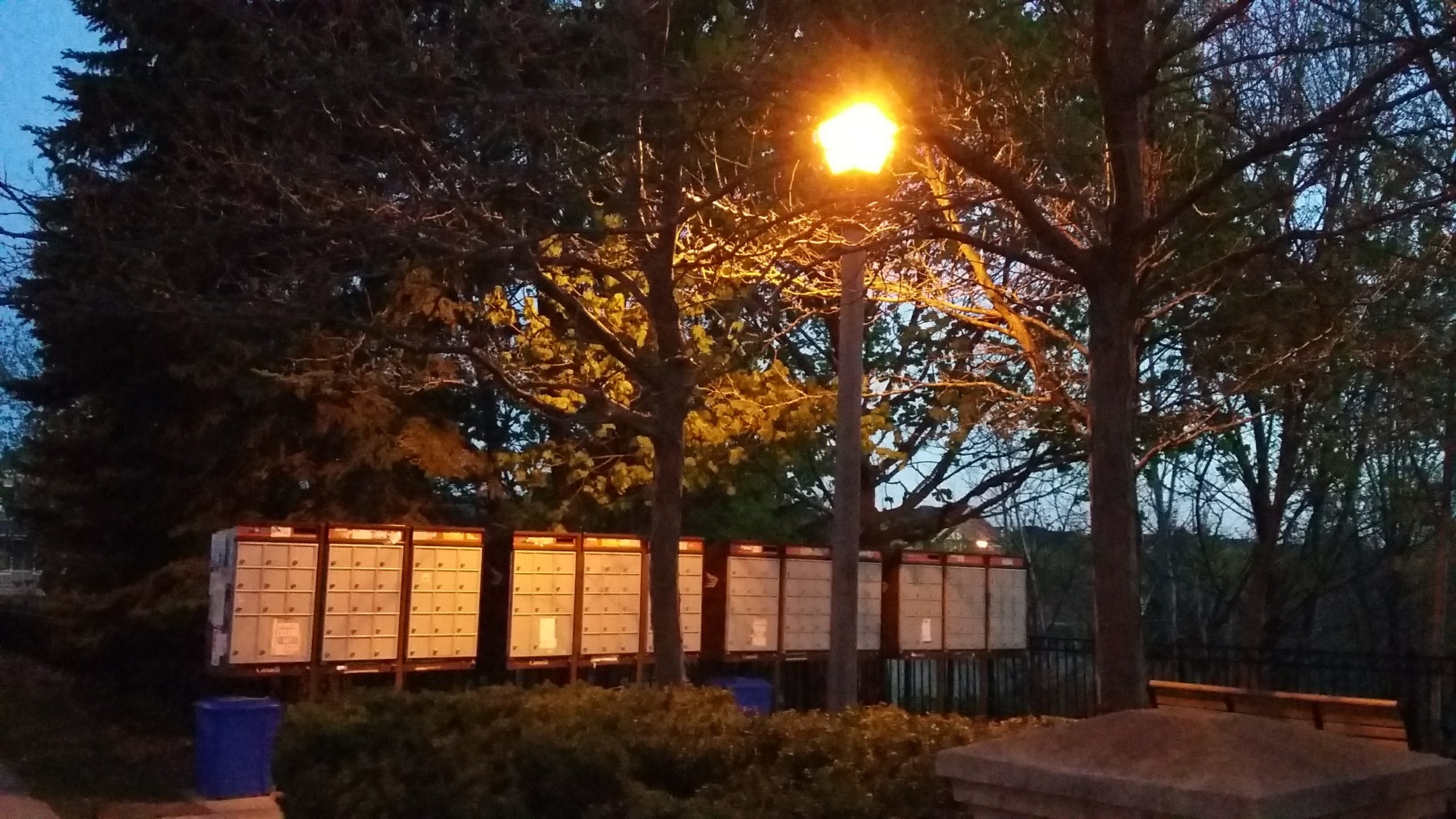 A row of metal mailboxes at dusk