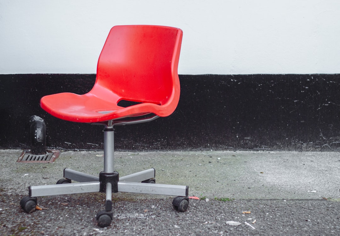 A red office chair on a concrete floor