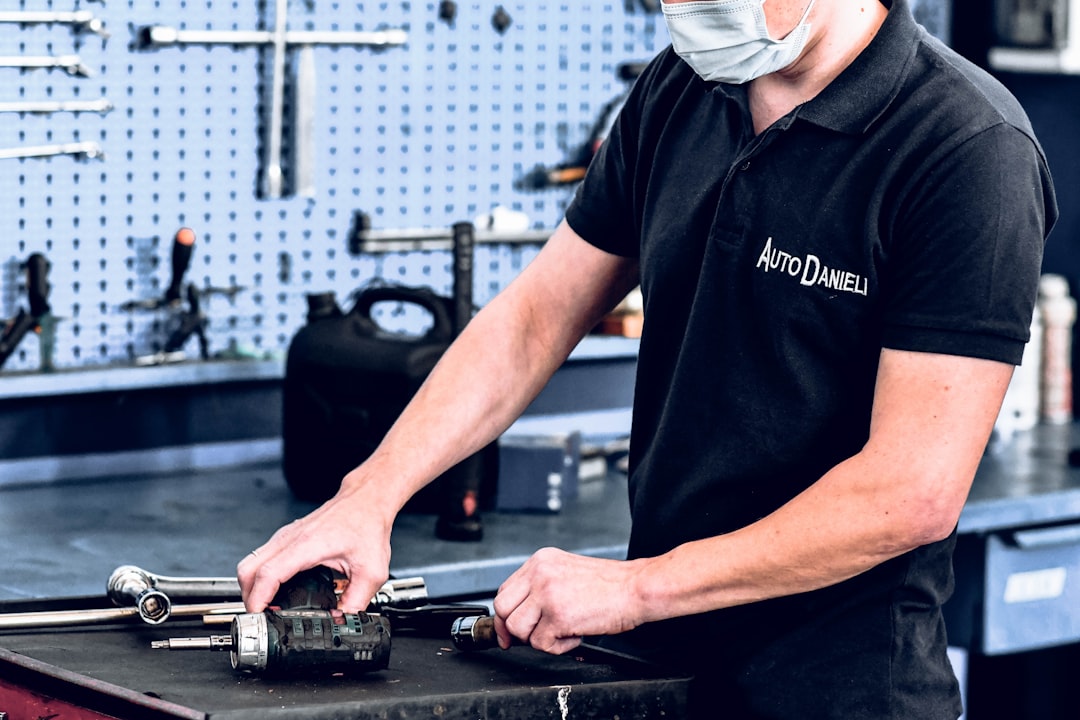 man in black polo shirt holding black and gray dj controller